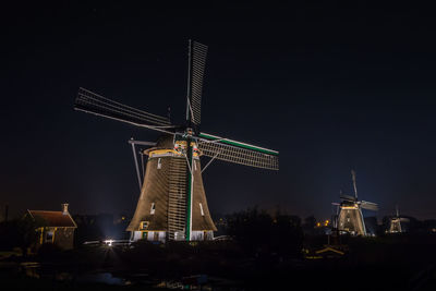 Low angle view of traditional windmill against sky at night