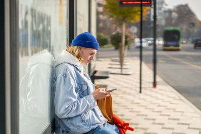 Side view of young woman standing in city