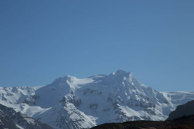 Scenic view of snowcapped mountains against clear blue sky