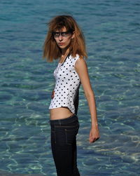 Portrait of young woman standing in sea