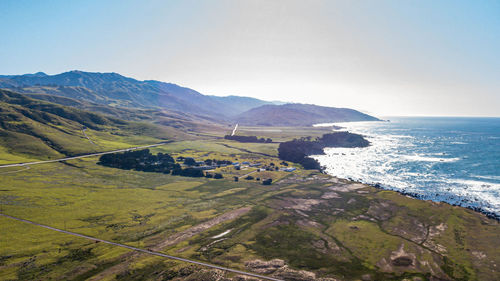 Scenic view of sea and mountains against clear sky