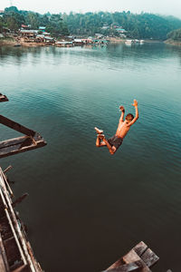 High angle view of men jumping over lake