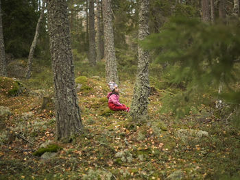 To toddler girl playing in forest