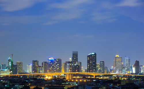 Illuminated buildings in city against sky at night