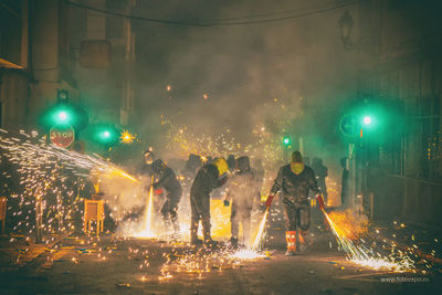 People on illuminated street at night
