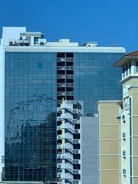 Low angle view of modern buildings against clear blue sky