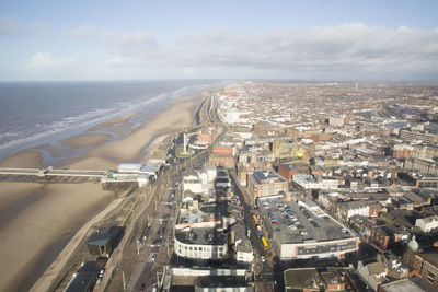 High angle view of cityscape by sea against sky