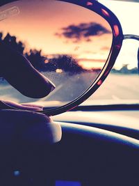 Close-up of cropped car against sky at sunset