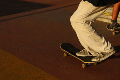 Low section of person skateboarding on floor