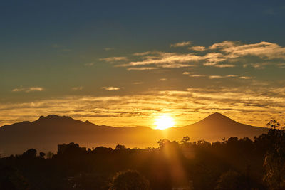 Scenic view of silhouette mountains against sky during sunset