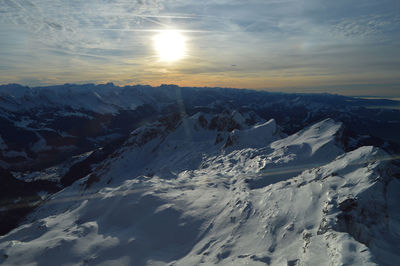 Scenic view of snowcapped mountains against sky during sunset