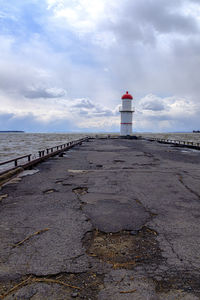 Lighthouse by sea against sky