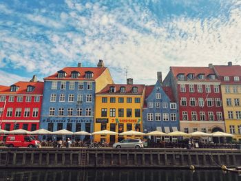 Low angle view of colorful buildings against cloudy sky