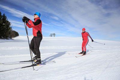 Men skiing on field against sky