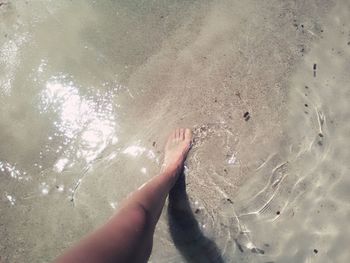 Close-up of hand on sand at beach