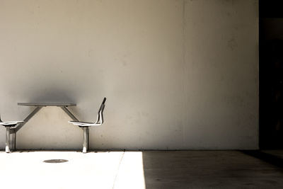 Empty chairs and table against wall at home