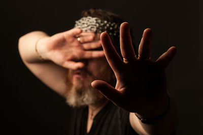 Midsection of woman holding hands over black background