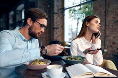 Young woman eating food at restaurant