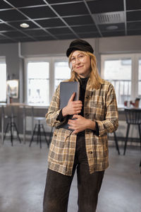 Smiling woman standing in office and looking at camera