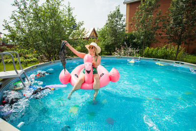 Woman jumping in swimming pool