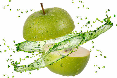 Close-up of water drops on fruit against white background