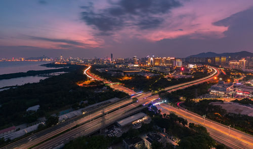 High angle view of illuminated city street and buildings at night