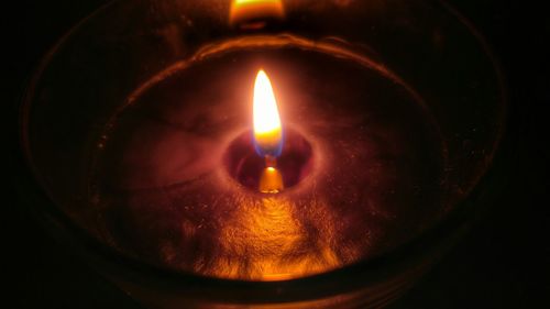 Close-up of lit candle in dark room