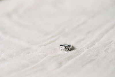 High angle view of wedding rings on bed