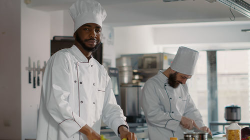 Portrait of chef preparing food at kitchen