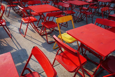 High angle view of empty chairs and tables at sidewalk cafe