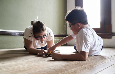 Mother with son playing on wooden floor