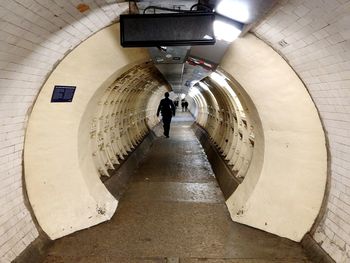 Rear view of man walking in subway station