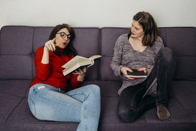 Young woman sitting on sofa at home