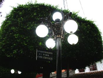 Low angle view of illuminated street light against building