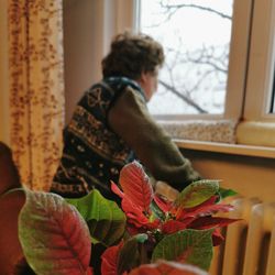 Rear view of woman by plants at home