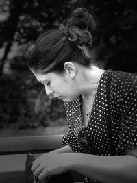 Close-up of mid adult woman looking down while sitting outdoors