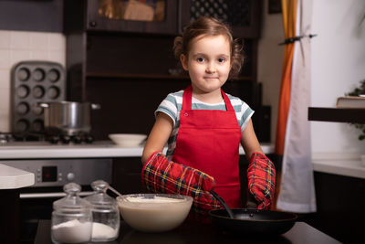 Portrait of cute girl preparing food in kitchen