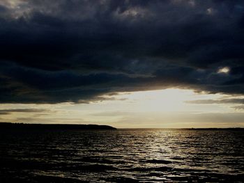 Scenic view of calm sea against cloudy sky