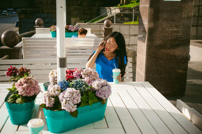 Woman having drink at sidewalk cafe