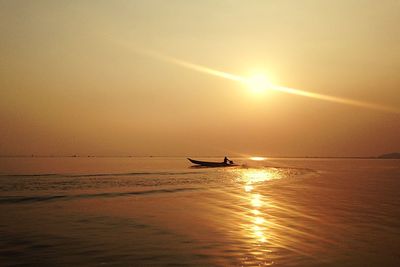 Silhouette boat in sea against sky during sunset