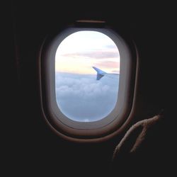 Cropped image of airplane flying over clouds