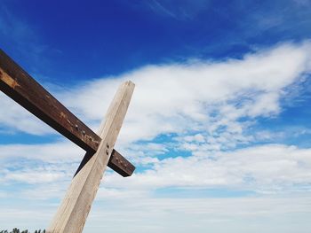 Low angle view of cross sign against blue sky