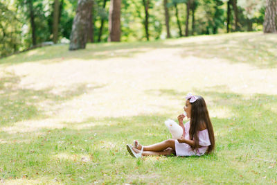 Child girl eats cotton candy on a sunny summer day and licks sticky fingers. walk with children 