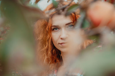 Portrait of woman seen through fruit tree