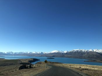 Scenic view of snowcapped mountains against clear blue sky