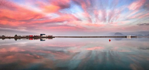 Scenic view of sea against dramatic sky during sunset