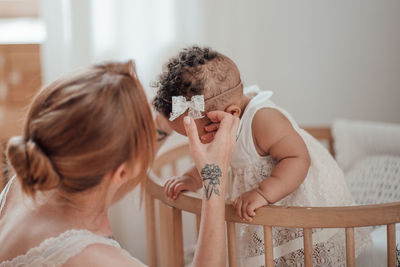 Rear view of mother and daughter at home