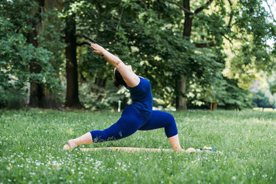 Happy confident smiling plus size curvy woman doing yoga stretching pilates workout, exercising