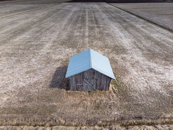 Aerial view of a lonely barn house on the springtime fields