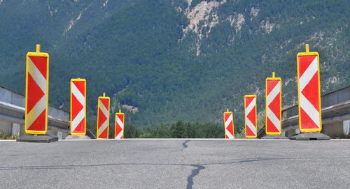 Road sign by street against city